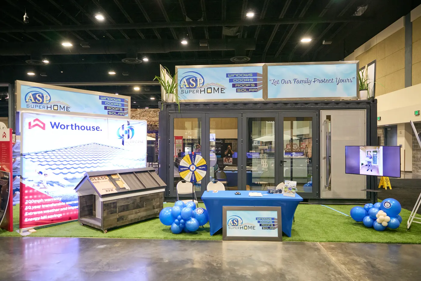 Exhibitor booth with glass doors and banners for windows, doors, roofing and solar