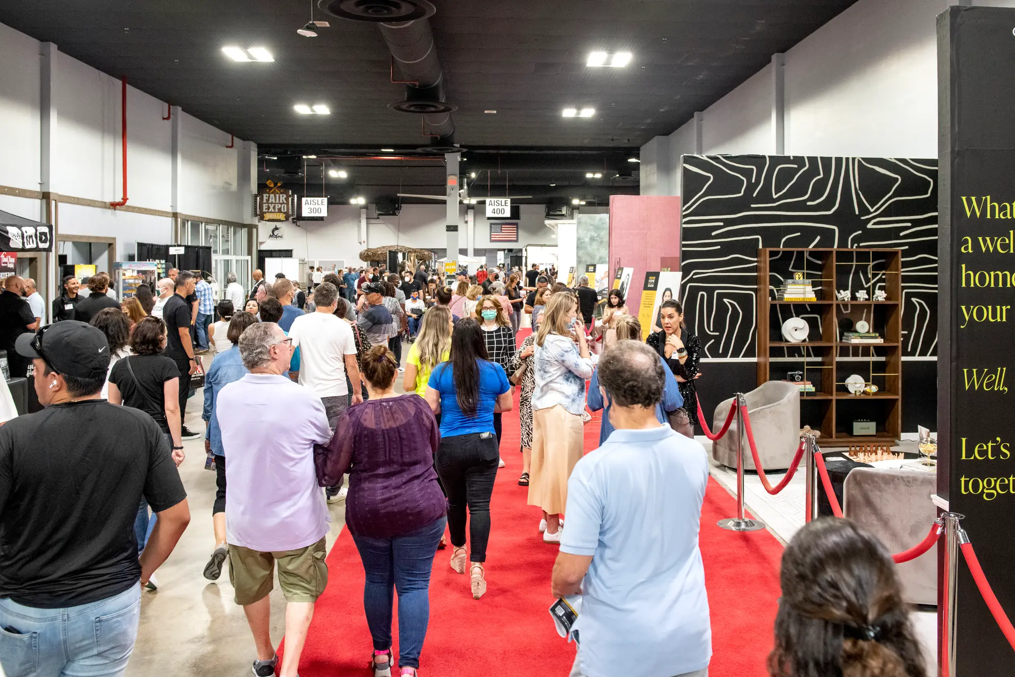 Crowd walking the main aisle of a packed home show floor
