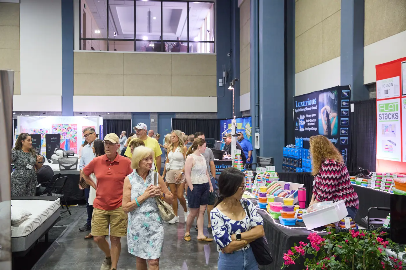Attendees browsing exhibitor booths along a busy show-floor aisle
