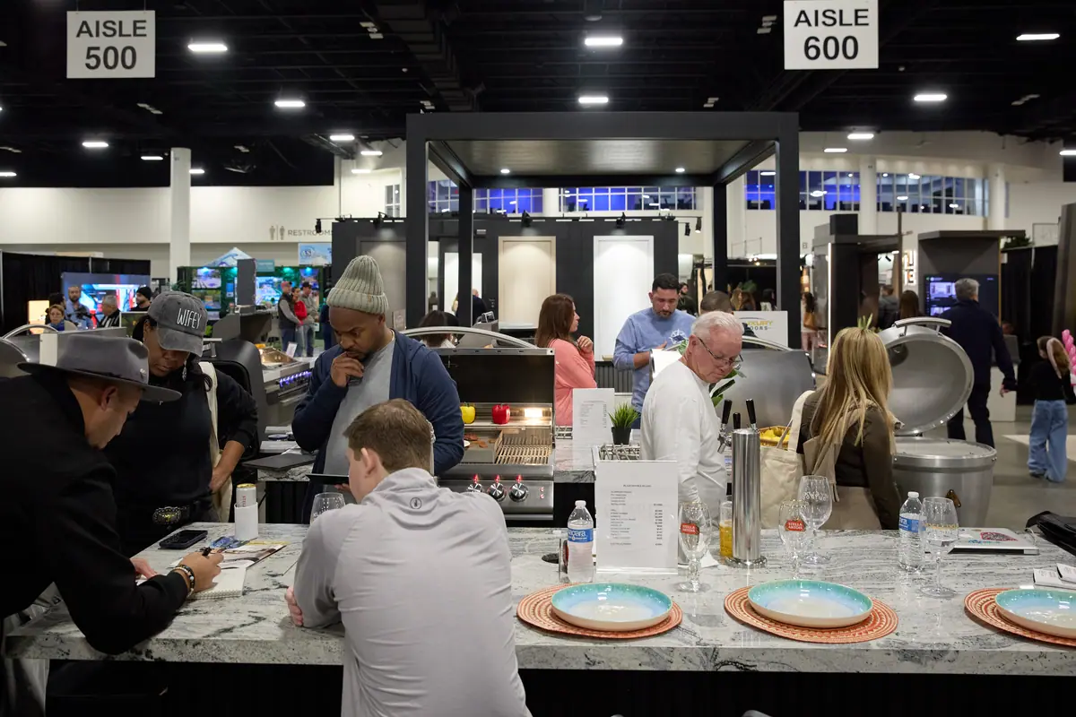 Visitors gathered around an outdoor kitchen island display at the Fort Lauderdale Home Show