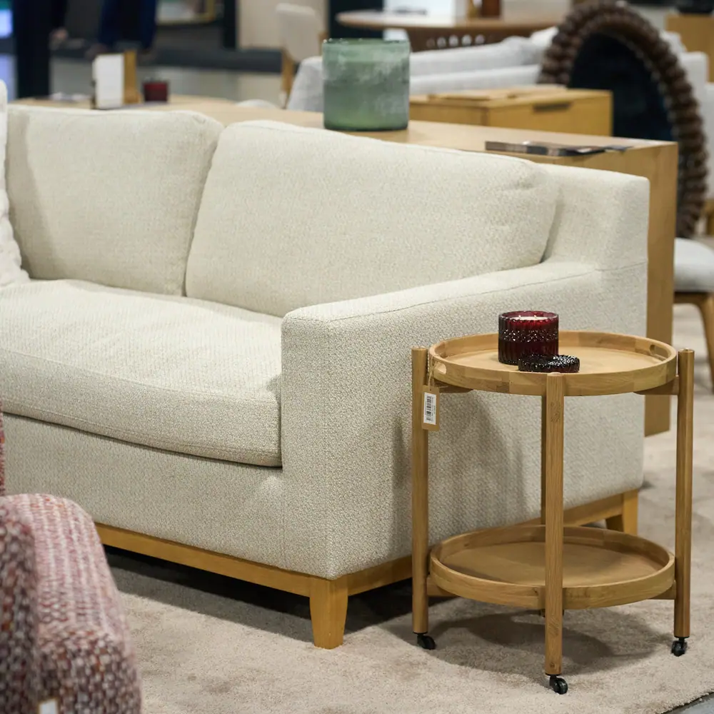 Cream sectional sofa and bamboo side table in a furniture showroom exhibit at a home show