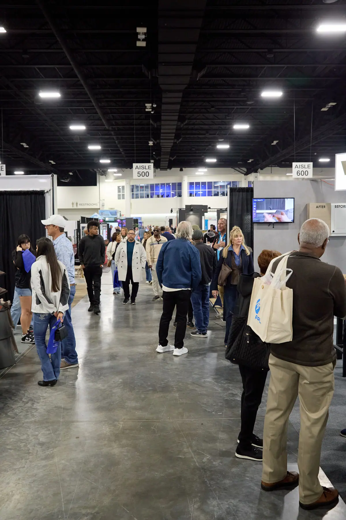 Attendees walk the main aisle between Aisle 500 and Aisle 600 at the home show