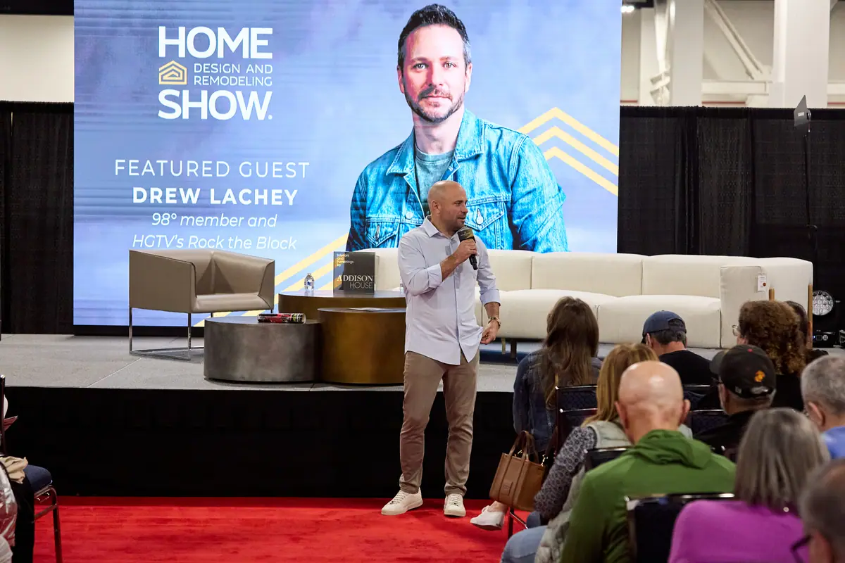 Host on stage at the Home Design and Remodeling Show with a Drew Lachey featured guest screen behind him