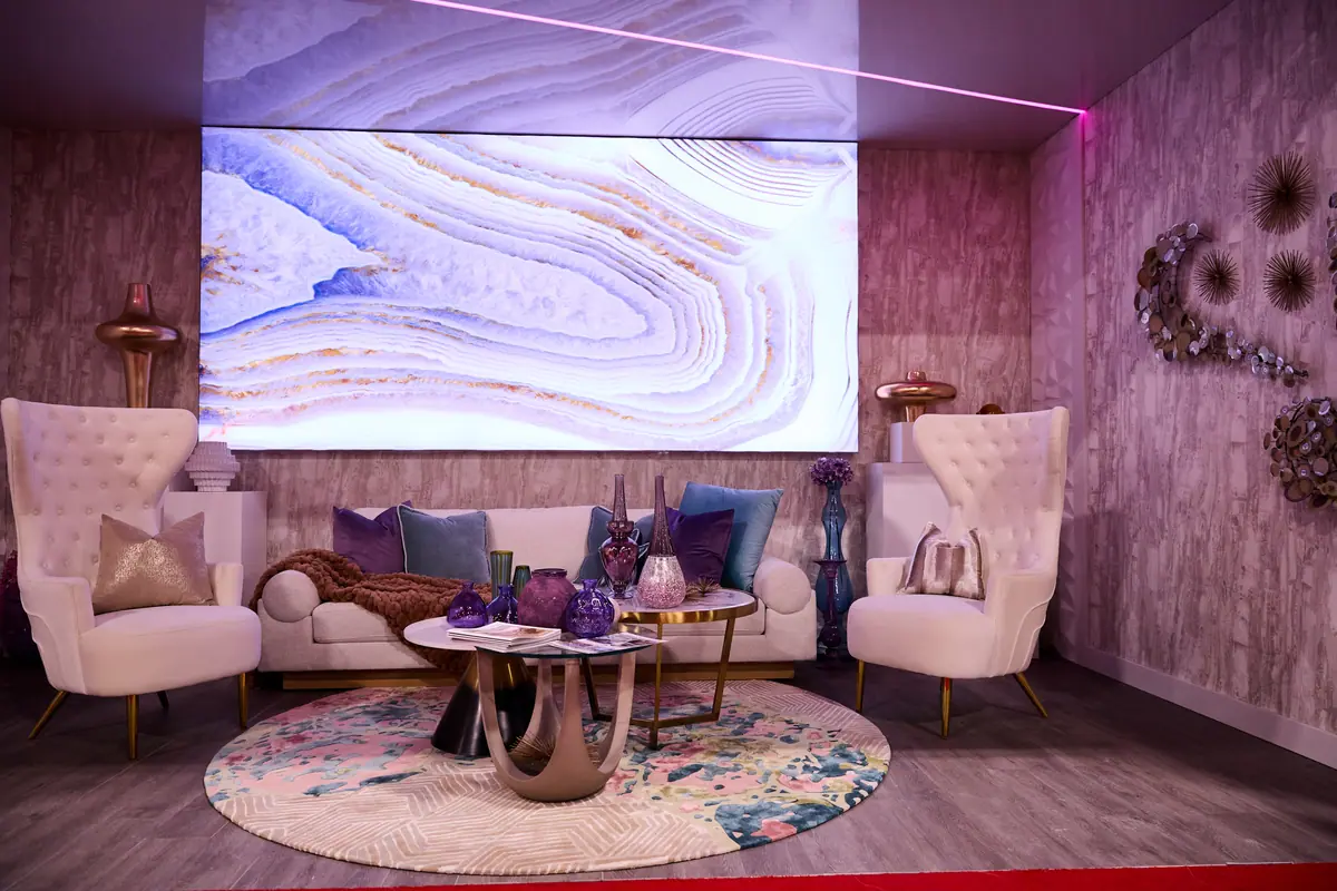 Glamorous VIP lounge with cream wingback chairs, jewel-toned decor, and a large LED agate wall display