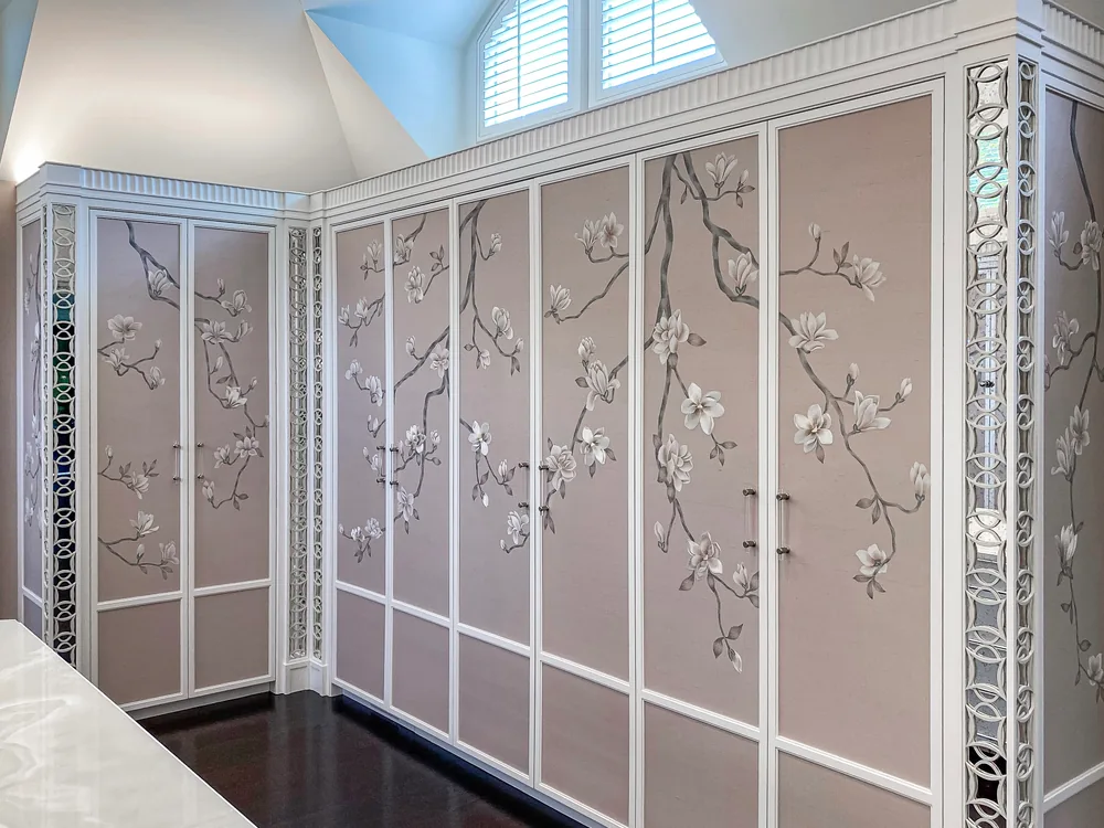 Fitted closet doors papered in a hand-painted cherry-blossom chinoiserie, seams matched across every panel
