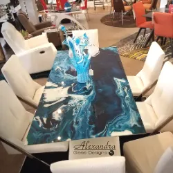 Dining table with turquoise ocean-pour resin top and white upholstered chairs