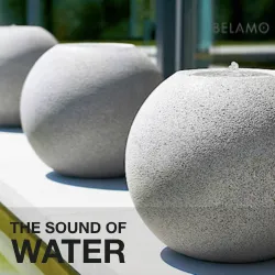 Pair of round concrete sphere fountains on a terrace with Belamo branding