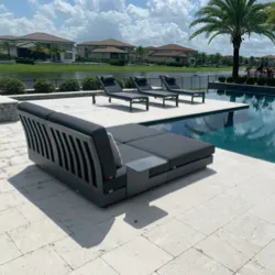 Modern dark grey sectional patio sofa set beside a pool with palm trees
