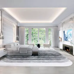 Bright modern master bedroom with floor-to-ceiling windows, grey area rug, and wall-mounted TV above fireplace