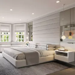 Contemporary white bedroom with upholstered panel headboard, pendant lights, and mirrored built-in shelving