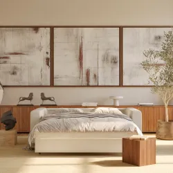Platform bed with cream upholstered headboard in warm minimalist bedroom with abstract triptych art