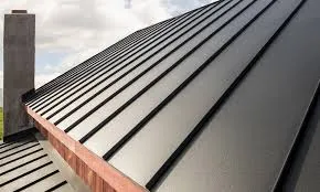 Close-up of dark grey standing seam metal roof panels with chimney stack