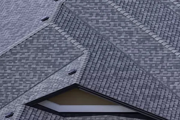 Overhead aerial view of grey architectural asphalt shingle roof with hip ridges and dormer window