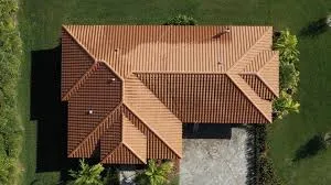 Aerial view of terracotta barrel tile roof on single-story Florida home surrounded by green lawn