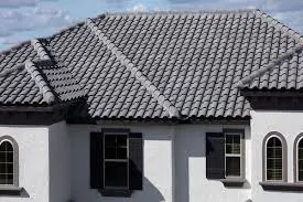 Close-up of dark gray concrete roof tiles on a white stucco Florida home