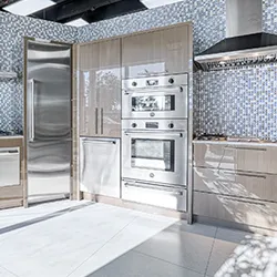 High-gloss taupe cabinetry with integrated oven and refrigerator in appliance showroom