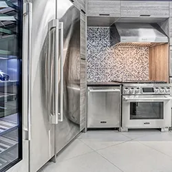 Stainless column refrigerator and professional range with mosaic backsplash in showroom