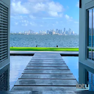 Waterfront dock view toward Miami skyline from luxury home with infinity pool
