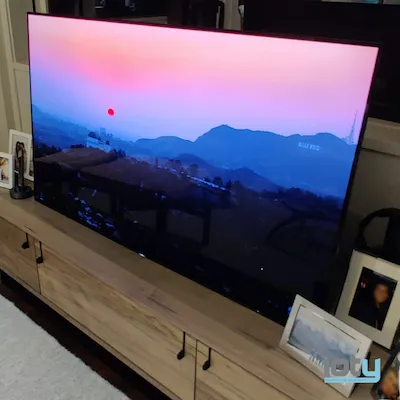 Large-format flat-screen TV displaying landscape scene mounted in living room