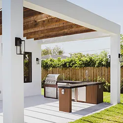 White-frame pergola over a built-in outdoor kitchen with stainless grill and wood-accent cabinetry