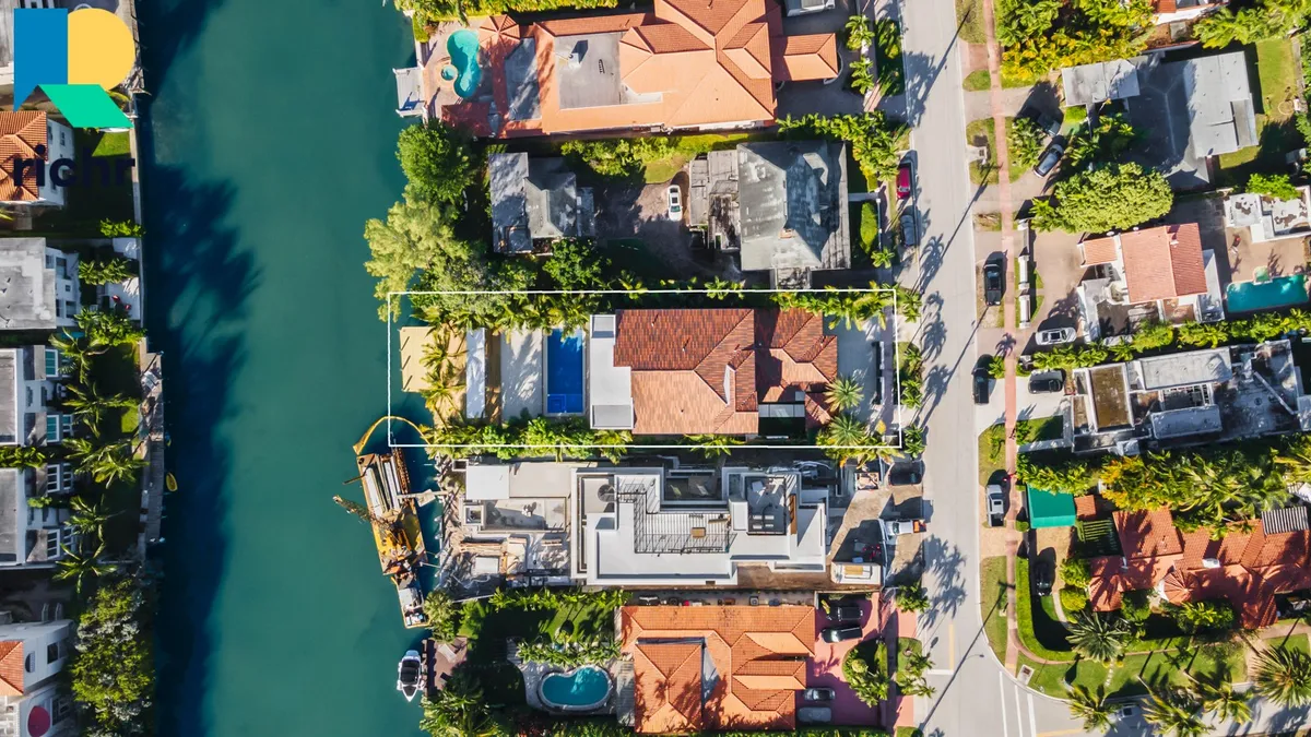 Top-down aerial of South Florida waterfront homes and canals with Richr logo overlay