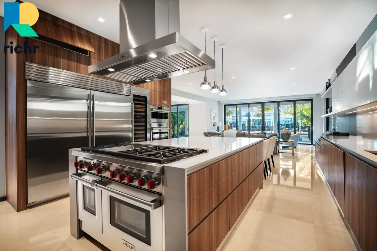 Luxury kitchen with Wolf range, large island, stainless appliances, and wood cabinetry, Richr logo overlay