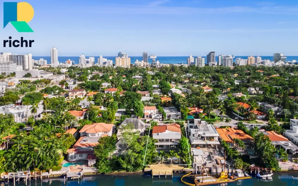Aerial view of South Florida waterfront neighborhood with a highlighted property and Miami skyline, Richr logo