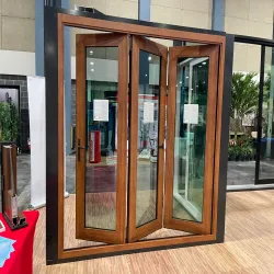 Wood-framed bifold impact door unit on display in a showroom setting