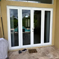 Newly installed white impact French doors with sidelights on a residential patio