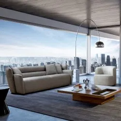 Contemporary gray sofa and armchair set in a high-rise living room with city skyline view