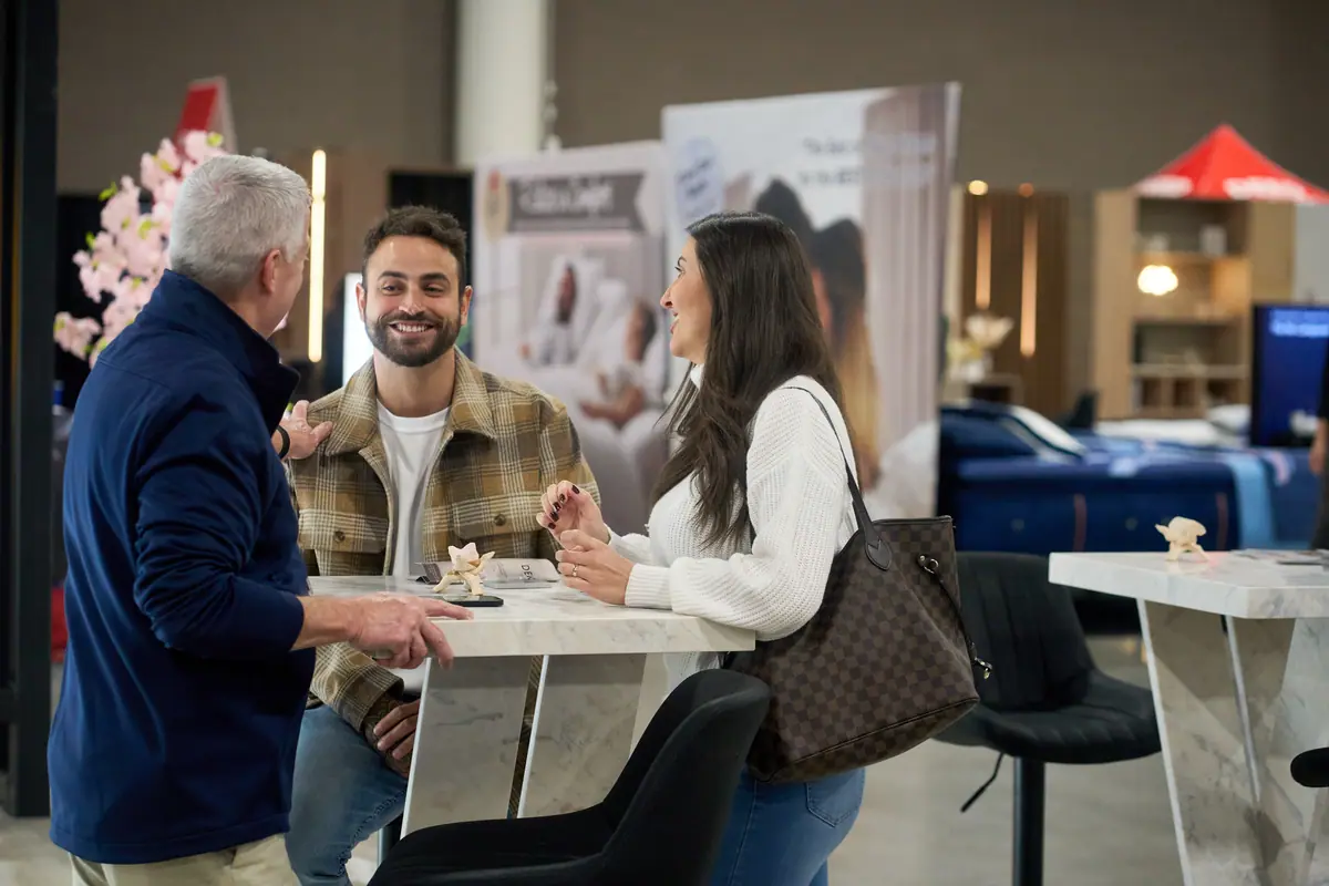 Exhibitor consultant chatting with an attendee couple at a furniture booth, Fort Lauderdale Home Show