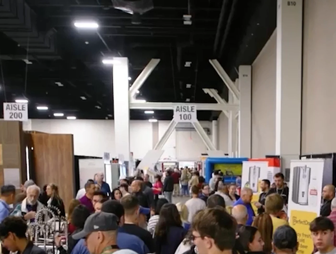 Packed show floor at the Palm Beach Home Show with crowds filling aisles 100 and 200